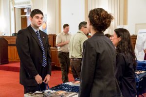 Two conservation professionals talk with a staffer from a Congressional member's office at an outreach event